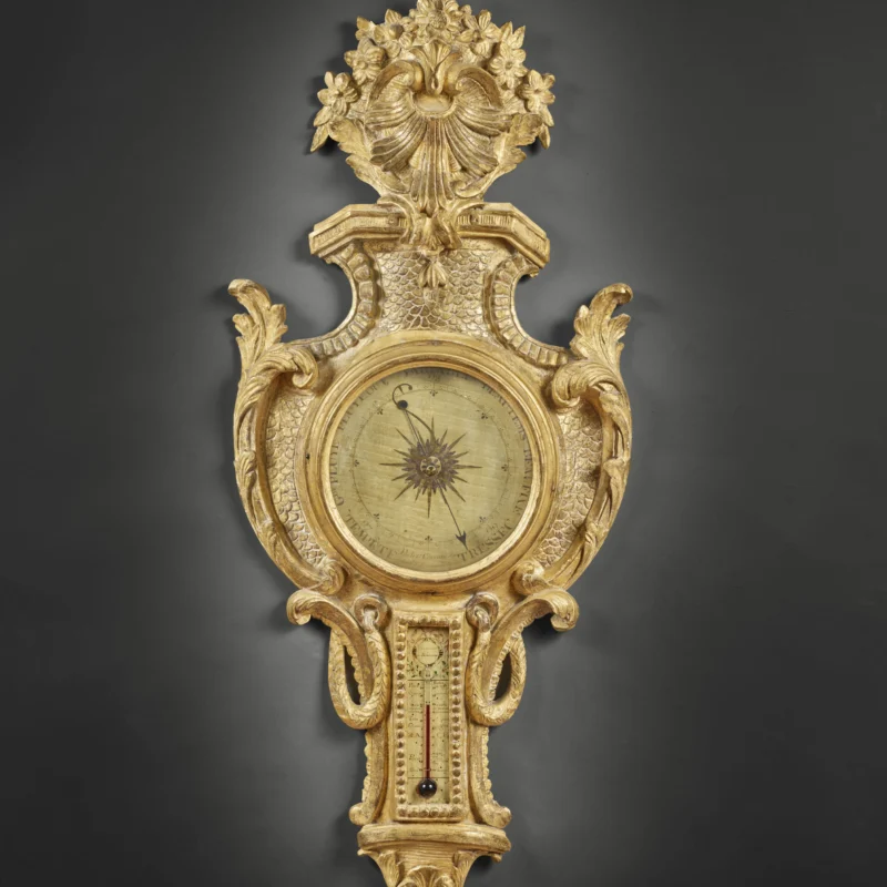 Baromètre-thermomètre Louis XVI en bois doré, signé Carcani, avec décor sculpté et cadran à aiguille.